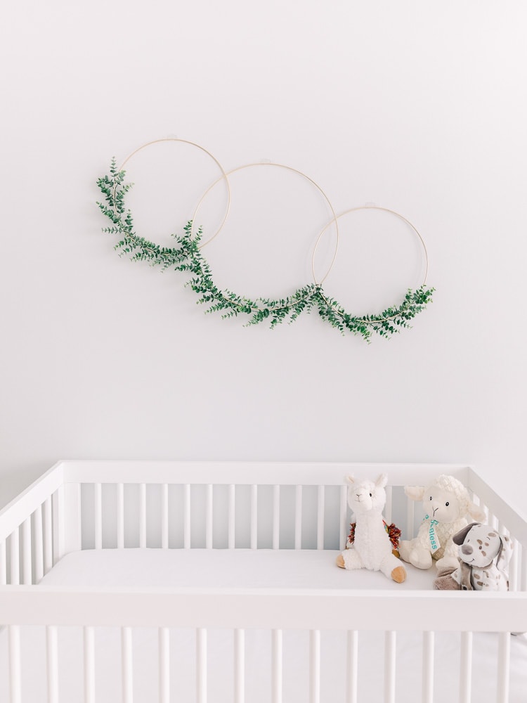 Metal wreath with greenery above crib, Modern Nursery Decor on a Budget, photography by Juliana Kaderbek Photography, Cleveland newborn photographer
