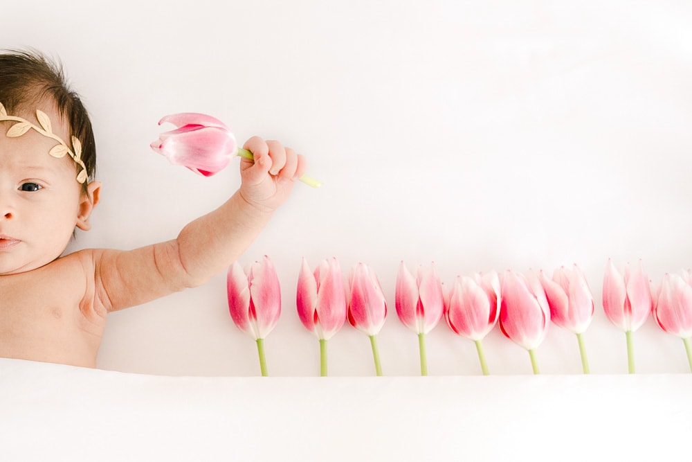 Newborn baby girl surrounded with flowers, In-home newborn photography photo inspiration by Juliana Kaderbek Photography, Cleveland Newborn Photographer