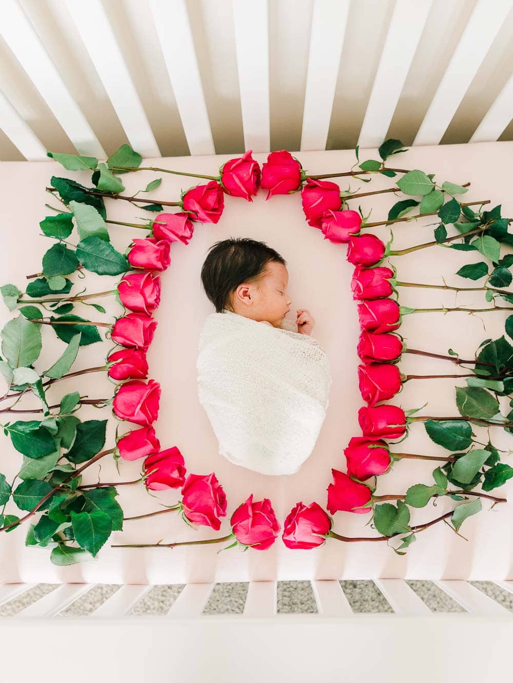 Newborn baby girl surrounded with flowers, Cleveland Newborn Photography, In-home newborn photography photo inspiration by Juliana Kaderbek Photography