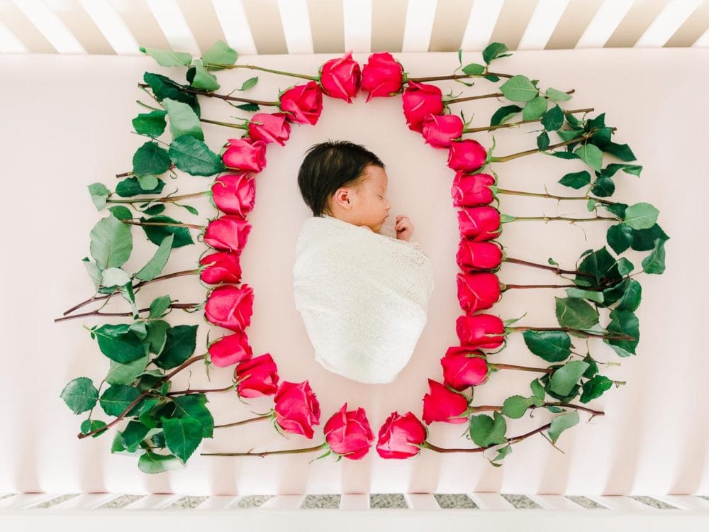 Newborn baby girl surrounded with flowers, Cleveland Newborn Photography, In-home newborn photography photo inspiration by Juliana Kaderbek Photography