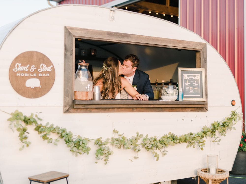 bride and groom share a kiss at their wedding mobile bar