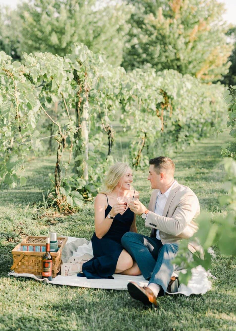 Couple sharing drinks during a picnic at their Gervasi Vineyard engagement session
