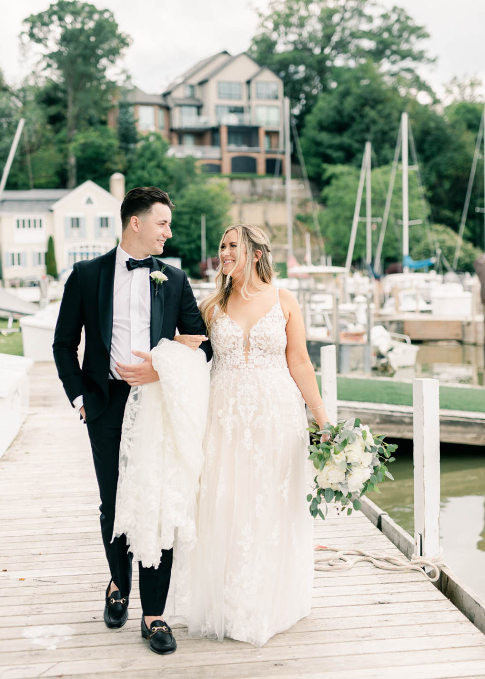 bride and groom walking on a dock before their ceremony