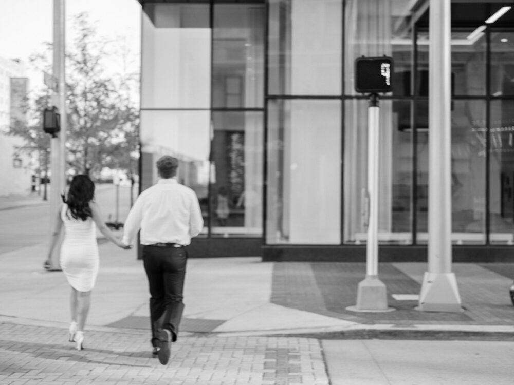 couple running across the street in Cleveland Ohio during their urban engagement session