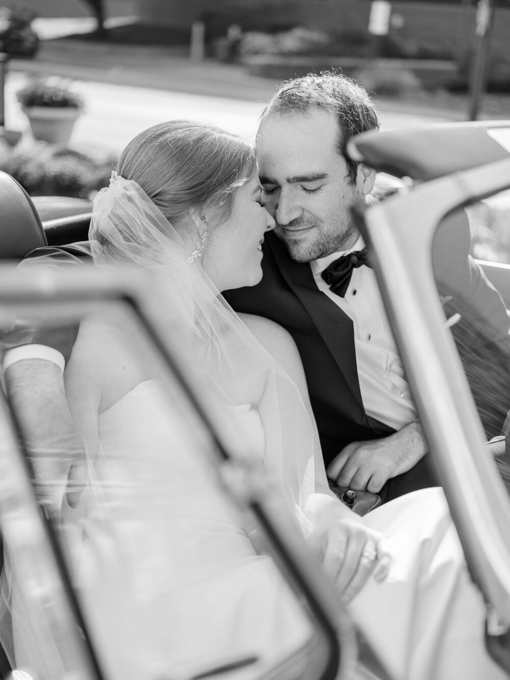 Bride and groom sharing a moment in a vintage car