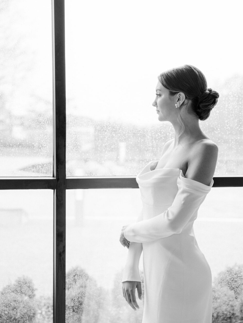 Bride looking out a window on a rainy wedding day in Orlando Florida