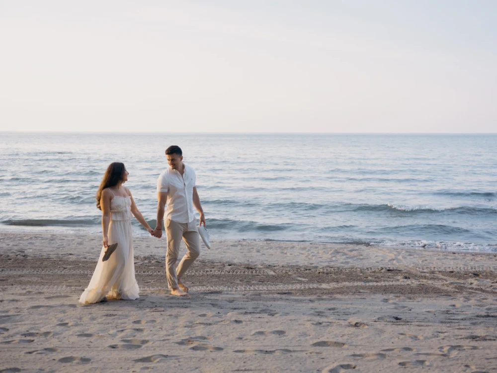 Bride and groom walking along the shore during their Charleston engagement session