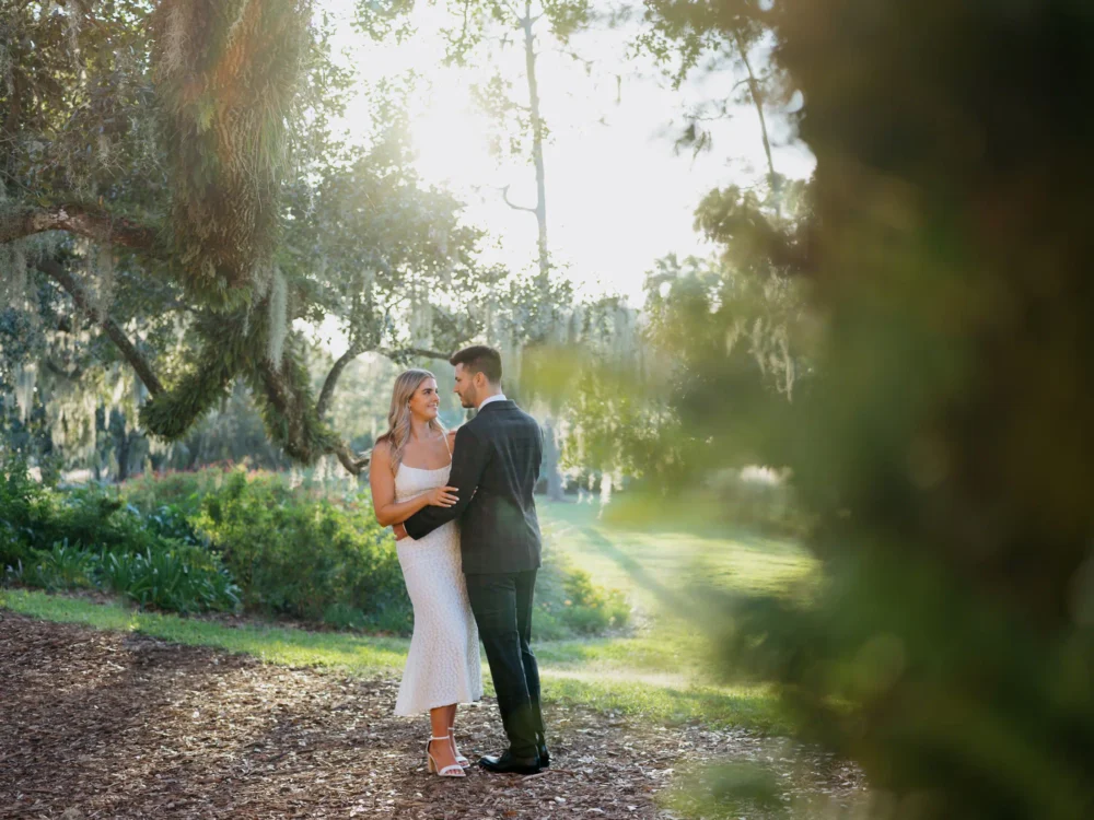 Bride and groom among moss covered trees during their engagement session in Charleston, SC