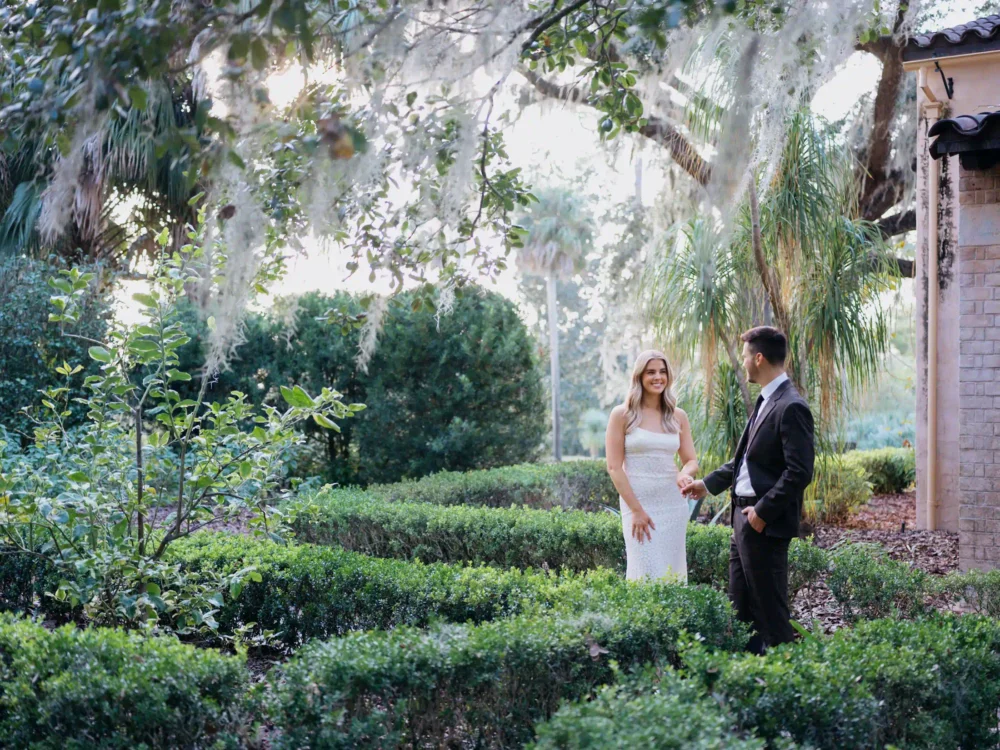 Bride and groom among moss covered trees during their engagement session in Charleston, SC