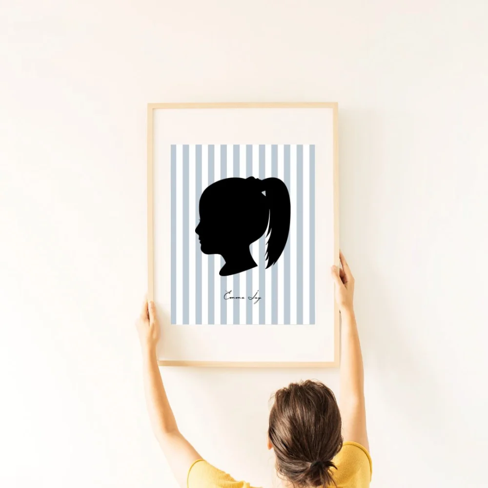 Person hanging up a personalized silhouette portrait on a wall
