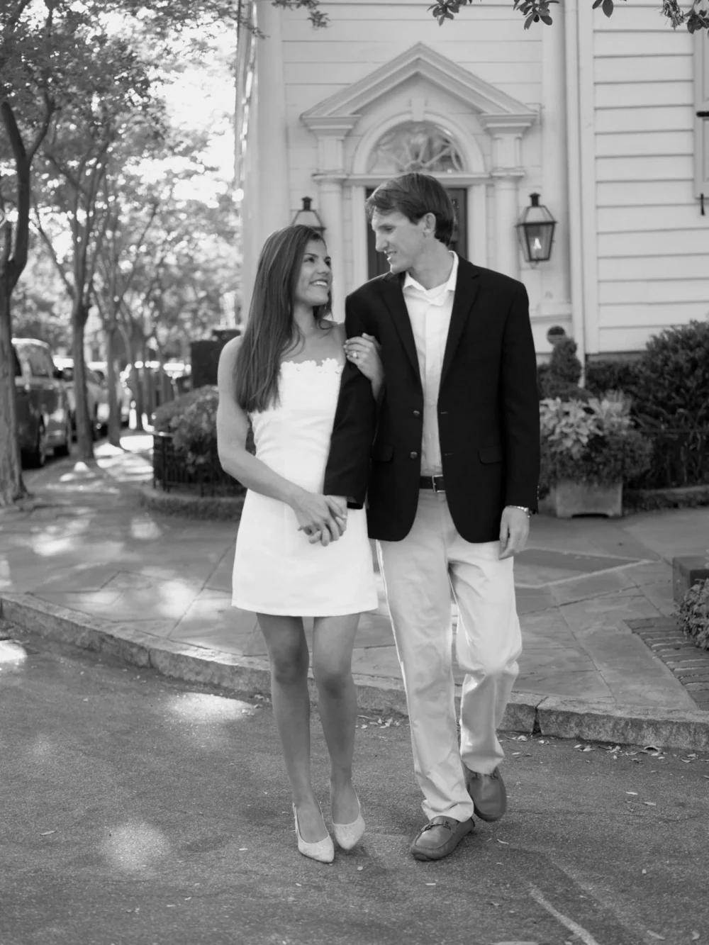 Couple walking through historic downtown Charleston during spring engagement session
