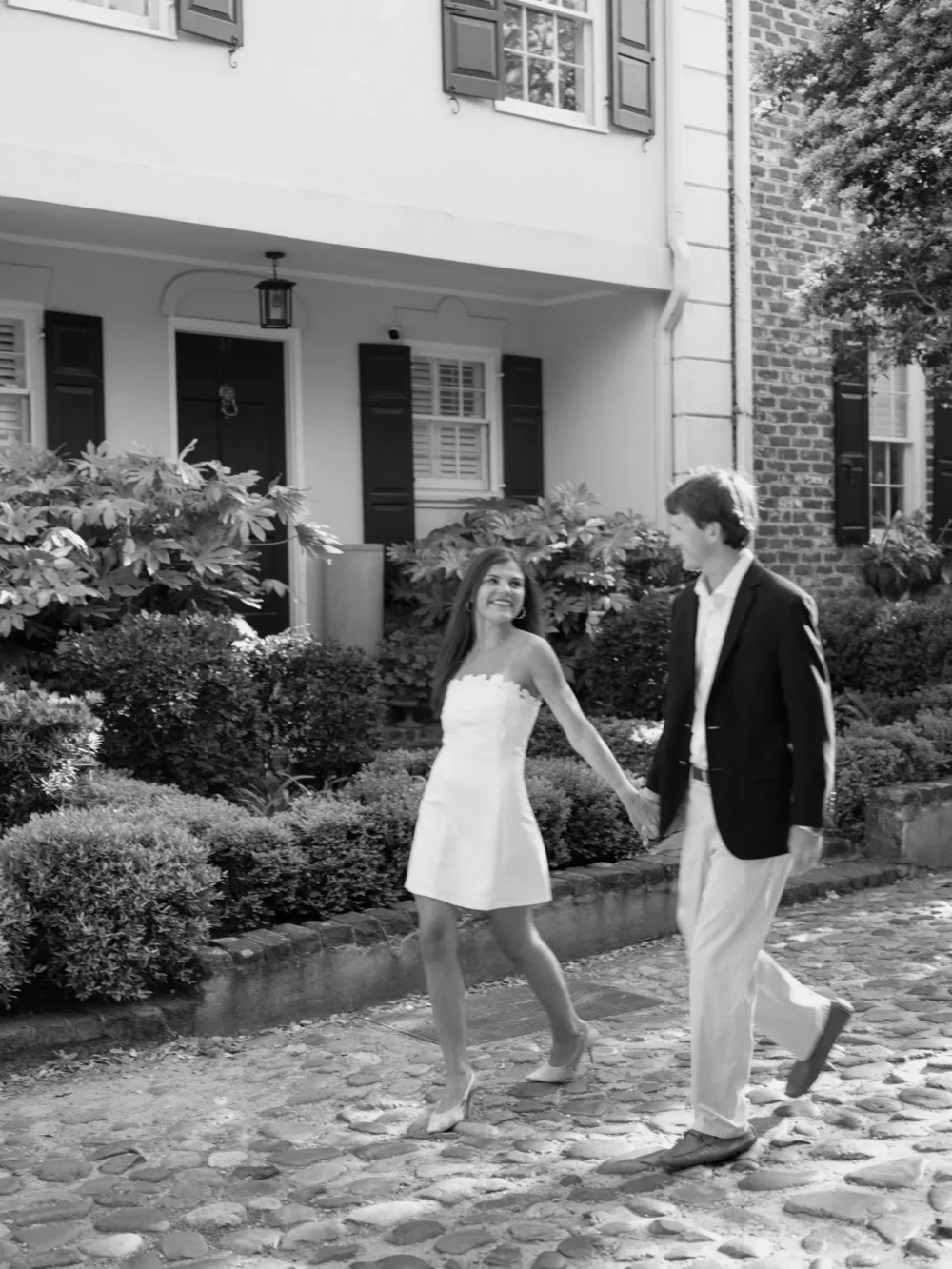 Couple walking through historic downtown Charleston during spring engagement session